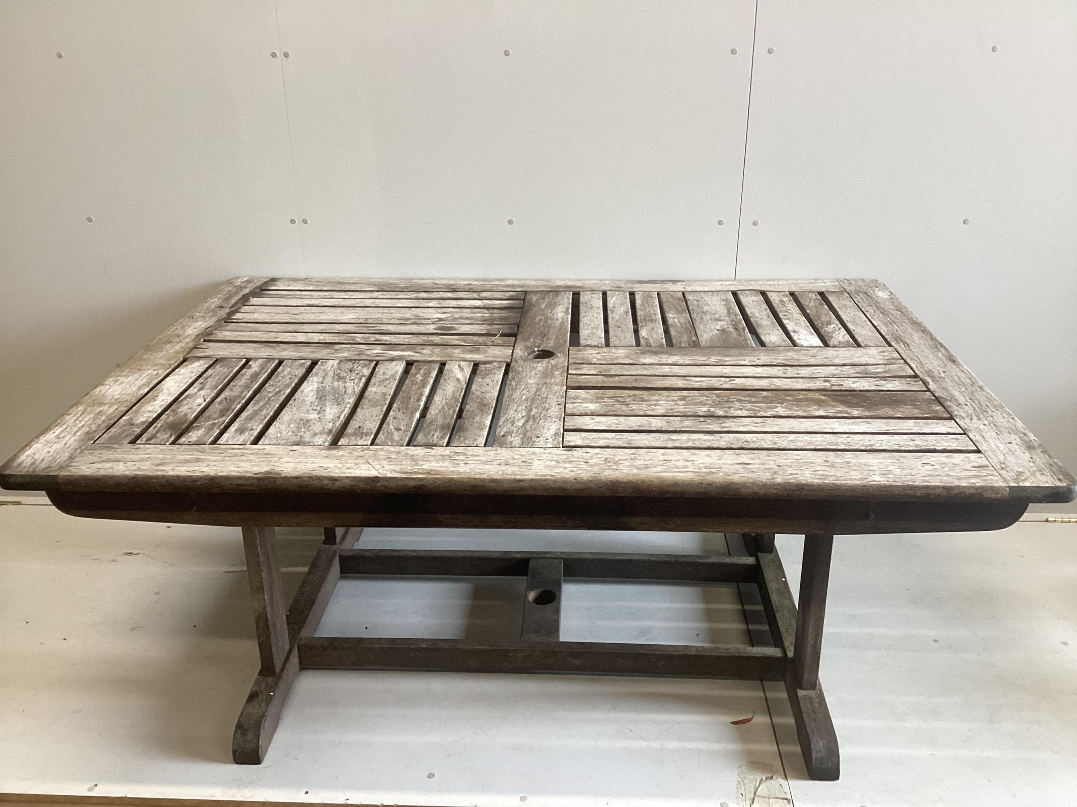 A vintage Bridgman & Co iroko hardwood rectangular garden table, width 182cm, depth 122cm, height 74cm and five chairs, two with arms. Condition - fair